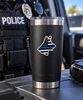 A black Yeti travel tumbler with a stainless steel lid and base, featuring a 'Thin Blue Line' dog graphic, set on a vehicle trunk with a police officer in the blurred background.