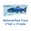 Real Sticky National Park Trout waterproof fishing sticker measuring 2 inches tall by 5 inches wide, featuring mountain scenery inside a trout silhouette on Made in USA retail packaging.